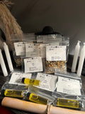 Kit Rituel des 4 Éléments avec quatre huiles de 5 ml, quatre sachets d’herbes de 5 g, quatre bougies carillon blanches de 10,2 cm et un parchemin de rituel pour pratiques spirituelles et ésotériques.