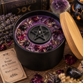 Bougie de la Sorcière 240 g en cire mauve avec pentacle noir, plantes rituelles et pierres, dans un pot noir avec couvercle en bambou.